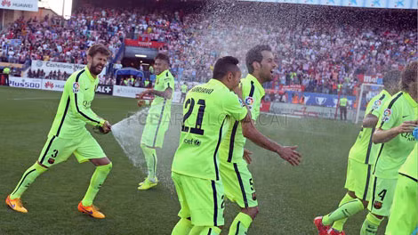 Pique không ngần ngại làm ướt đồng đội ngay bằng rượu Champagne. Ảnh: FCBarcelona.com