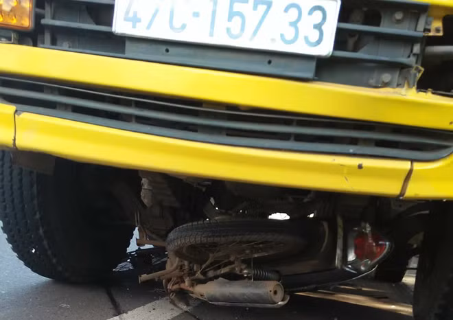 Chiếc xe máy của bà Trọng bị cuốn vào gầm xe tải