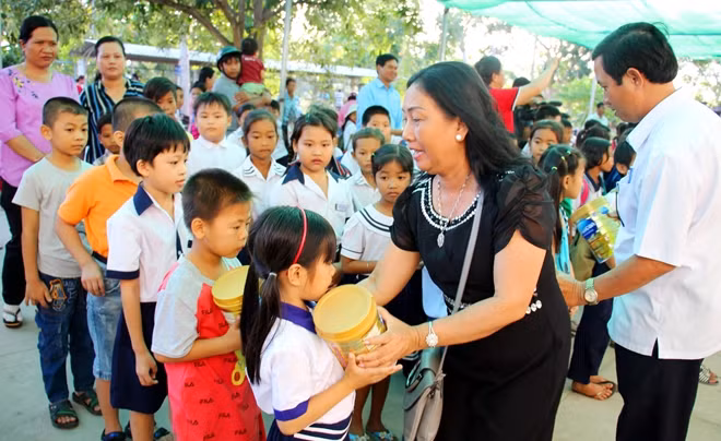 Mạnh thường quân trao sữa cho các em học sinh.