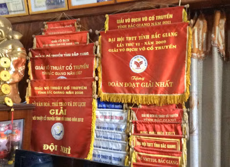 Huy chương và cờ lưu niệm mà các võ sinh của ông Sơn đạt được.