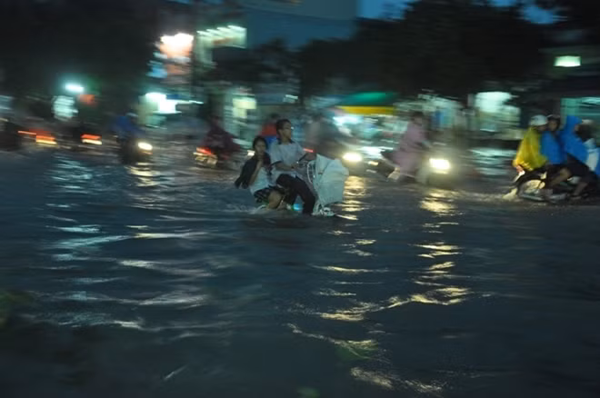 Học sinh thích thú khi tan trường trong cơn mưa lớn.
