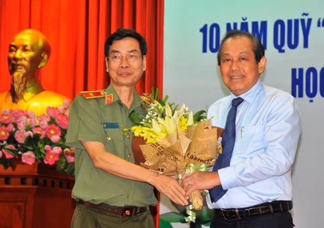 Thiếu tướng Phạm Văn Miên-Tổng biên tập Báo Công an nhân dân tặng hoa cho đồng chí Trương Hòa Bình, Ủy viên Bộ Chính trị, Phó Thủ tướng Thường trực Chính phủ