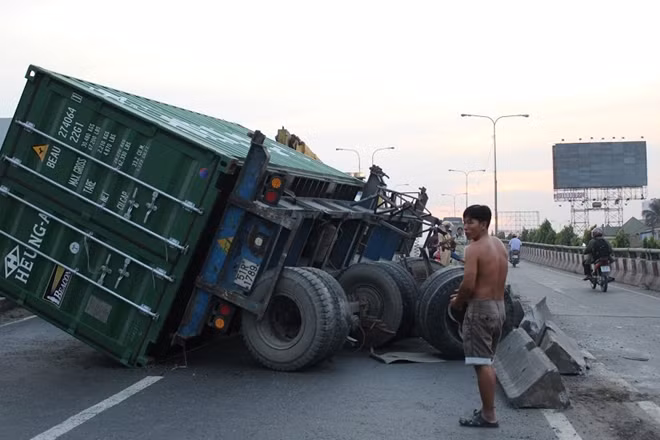 Thùng xe bị lật xuống đường, bánh xe gãy văng ra ngoài khỏi xe