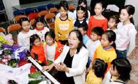 NSND Tường Vi đang dạy trẻ em hát.