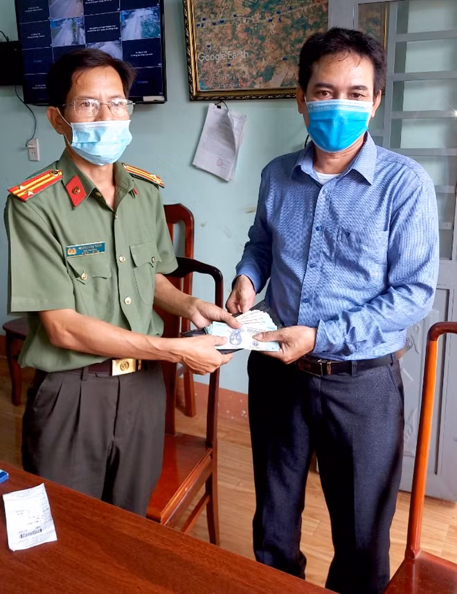 Trưởng Công an xã Đồng Tiến trao trả chiếc ví cùng số tài sản và giấy tờ cho anh Khang.