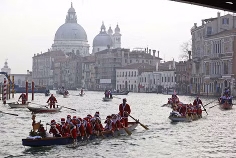 Những người dân trong trang phục “ông già Noel” chèo thuyền tại Venice.