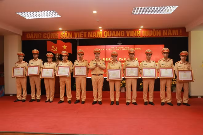 Thừa uỷ quyền của Bộ trưởng Bộ Công an, Đại tá Nguyễn Văn Trung, Cục trưởng Cục CSGT trao Bằng khen cho các tập thể có thành tích xuất sắc