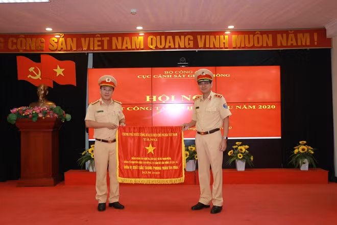 Thừa uỷ quyền của Thủ tướng Chính phủ, Trung tướng Vũ Đỗ Anh Dũng, nguyên Cục trưởng Cục CSGT trao Cờ Thi đua cho đơn vị có thành tích xuất sắc