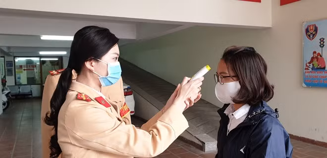 Cán bộ Đội CSGT số 2 đo thân nhiệt người dân trước khi làm việc
