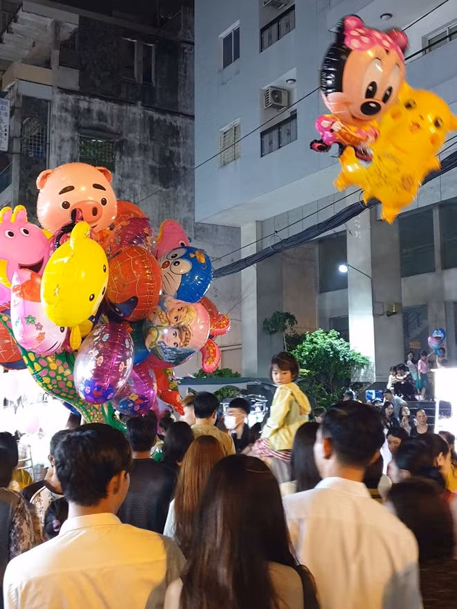 Phụ huynh phải kiệu trẻ em lên vai mới có thể đi vào dòng người.