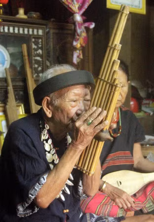 Già làng Quỳnh Hoàng đang thổi điệu khèn truyền thống của dân tộc Tà Ôi.