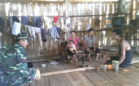 Cán bộ Công an đang thông báo đặc điểm nhận dạng nghi can Đặng Văn Hùng cho người dân.