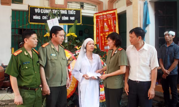 Đại diện Báo CAND trao quà của Báo cho gia đình đồng chí Đạt.