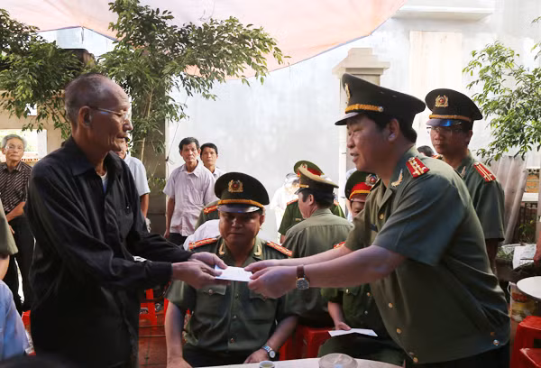 Đại tá Phạm Hồng Sơn, Giám đốc Công an tỉnh Bắc Ninh trao tiền hỗ trợ cho đại diện gia đình đồng chí Nguyễn Công Đạt.