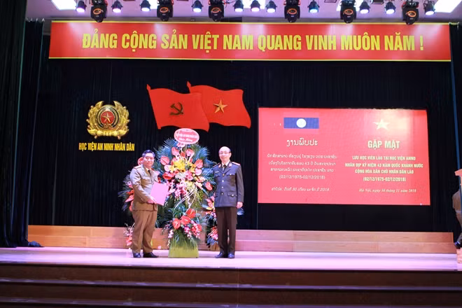 Thiếu tướng Nguyễn Quý Khoát, Phó Giám đốc Học viện ANND tặng hoa và quà của Học viện cho đại diện lưu học sinh Lào