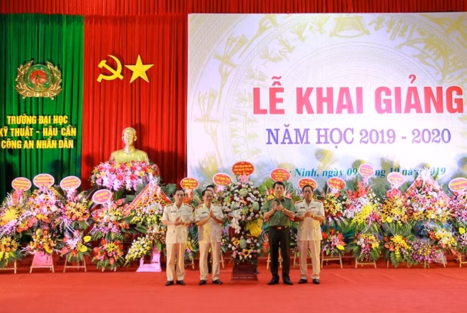 Thứ trưởng Lương Tam Quang tặng hoa cho lãnh đạo nhà trường