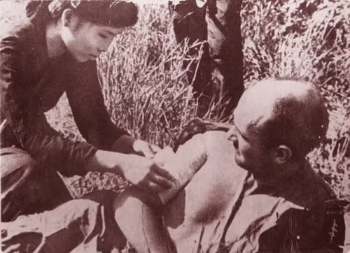 Nữ du kích băng bó vết thương cho một lính Mỹ.