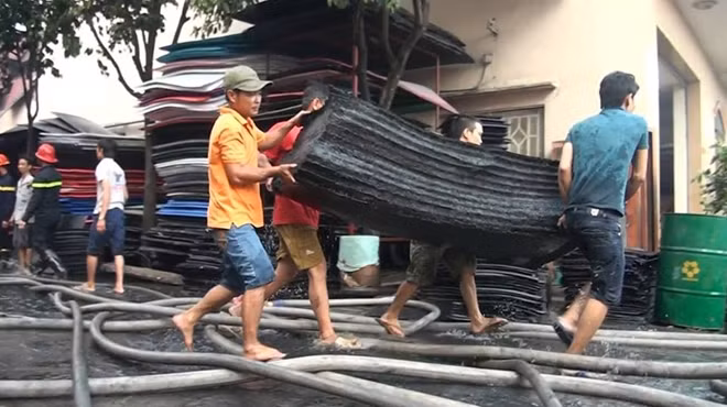 Công nhân di dời các vật liệu trong xưởng ra ngoài