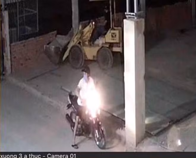 Đói tượng đứng ngoài và đối tượng vào lấy máy xúc lái ra