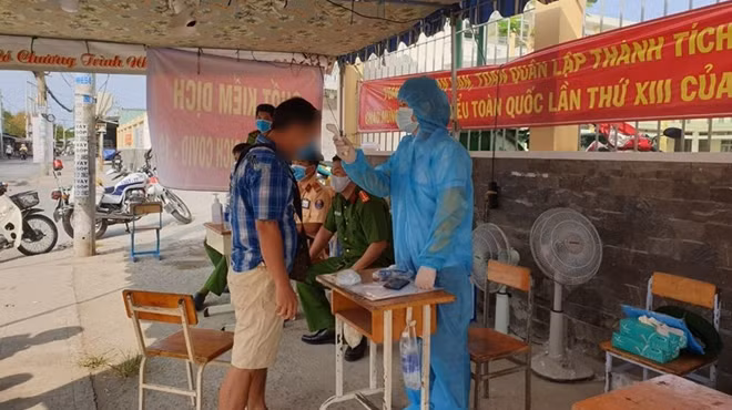Nhân viên y tế đo thân nhiệt người dân