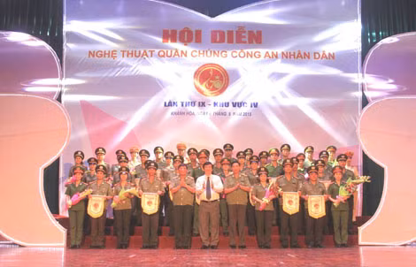 Trung tướng Lê Văn Đệ - Phó Tổng cục trưởng Tổng cục chính trị CAND và lãnh đạo UBND tỉnh Khánh Hòa trao cờ lưu niệm cho các đoàn tham gia Hội diễn NTQC CAND khu vực IV.
