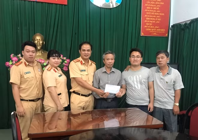 Ban chỉ huy Đội CSGT-TT, Công an quận 12, tặng quà cho Thượng sĩ Trần Đức Mạnh (thứ hai từ phải sang).