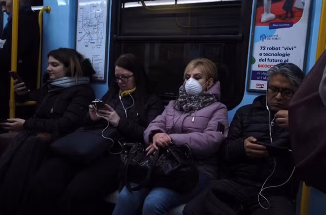 Người dân Italia lo lắng trước dịch bệnh trên một chuyến tàu tại Milan hôm 27/2. Ảnh: Reuters
