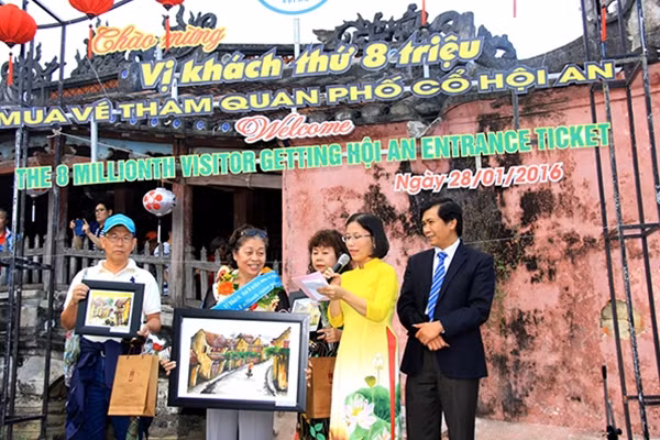 Đại diện chính quyền TP. Hội An tặng quà lưu niệm cho vị khách thứ 8 triệu mua vé tham quan phố cổ Hội An.