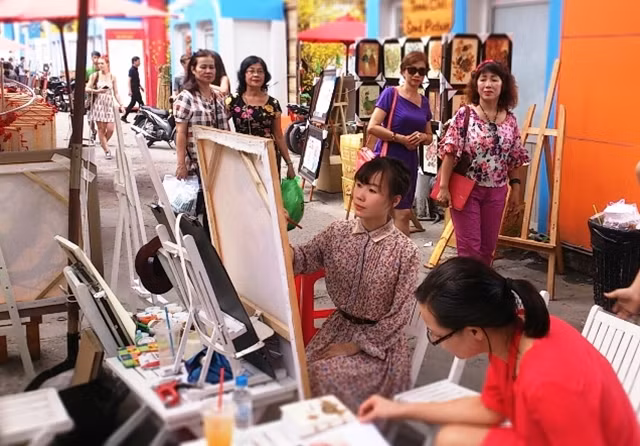 Nhiều khách tham quan muốn ghi lại hình ảnh của mình trên các bức họa của nữ họa sĩ trẻ.