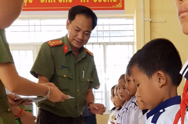 Thượng tá Nguyễn Văn Tiển, Phó trưởng Công an Quận 12 trào quà cho các em học sinh nghèo học giỏi