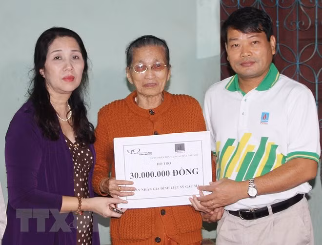 Đại diện Liên đoàn Lao động tỉnh Quảng Trị và Quỹ từ thiện xã hội Tấm lòng Vàng (Báo Lao động) trao số tiền hỗ trợ cho bà Trần Thị Giỏ, trú tại thành phố Đông Hà, là mẹ của liệt sỹ Tống Sỹ Bái hy sinh trong trận chiến đấu bảo vệ chủ quyền biển đảo Tổ quốc ở Gạc Ma năm 1988. (Ảnh: Hồ Cầu/TTXVN)