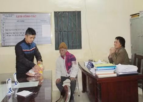 Cán bộ Công an xã Vĩnh Quỳnh mua bánh mì và sữa cho ông Hải.