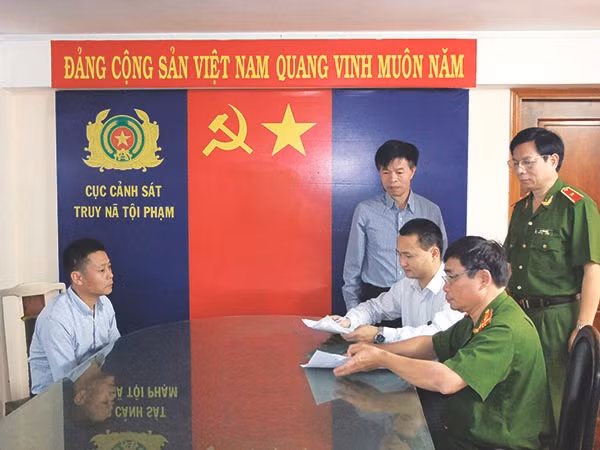 Cán bộ Cục Cảnh sát truy nã tội phạm, đại diện cơ quan Cảnh sát Bộ Công an Trung Quốc lấy lời khai đối tượng truy nã quốc tế.