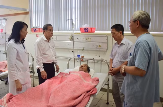 Chủ tịch UBND tỉnh Thừa Thiên- Huế Phan Ngọc Thọ (thứ 2 từ trái sang) thăm hỏi bệnh nhân Hoàng Trọng Niệm nằm điều trị tại Bệnh viện Trung ương Huế sau khi bị "cát tặc" chém trọng thương.