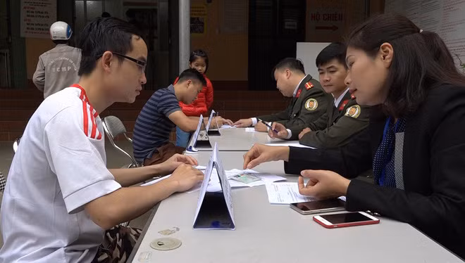 Cán bộ Phòng Quản lý Xuất, nhập cảnh Công an tỉnh Lào Cai hướng dẫn người dân làm thủ tục.