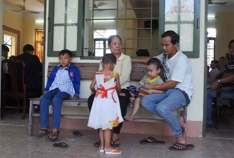 Bé Ngân (váy hoa) được người thân đưa đến dự phiên tòa.