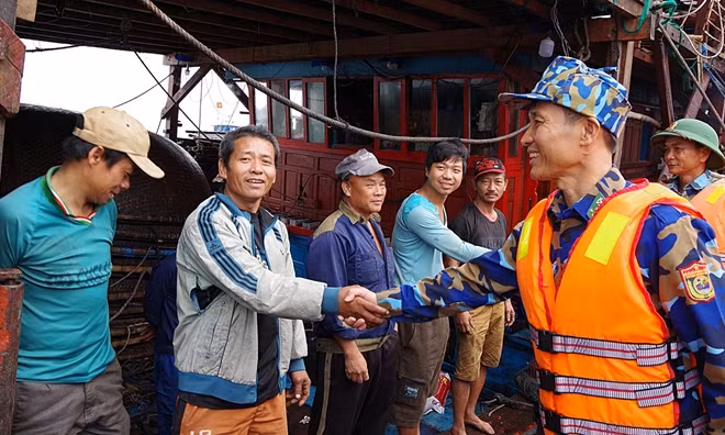 Cán bộ chiến sĩ Hải đội 2 thăm hỏi ngư dân sau khi vào bờ an toàn.