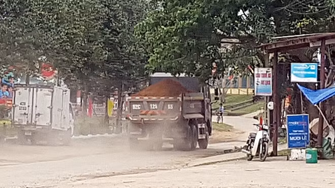 Bụi bay mù mịt khi chiếc xe chở đất đi qua.