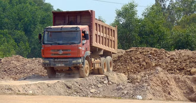 Đổ đất vào bãi tập kết để chờ xe tải của nhà xe Lê Trần đến nhận hàng chuyển đi tiêu thụ.
