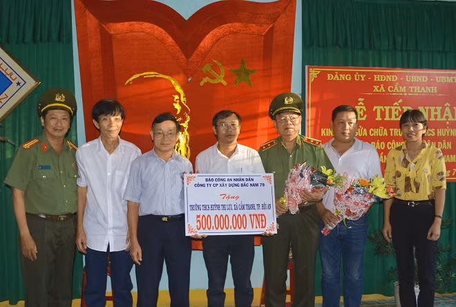 Trung tướng Lê Ngọc Nam cùng đại diện Báo CAND và Công ty CP Xây dựng Bắc Nam 79 trao tặng 500 triệu đồng cho BGH Trường THCS Huỳnh Thị Lựu.