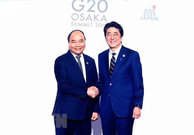 Thủ tướng Nhật Bản Shinzo Abe đón Thủ tướng Nguyễn Xuân Phúc. (Ảnh: Thống Nhất/TTXVN)
