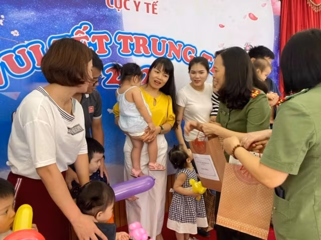 Đại tá Phạm Thị Lan Anh, Bí thư Đảng uỷ, Cục trưởng tặng quà cho các cháu.