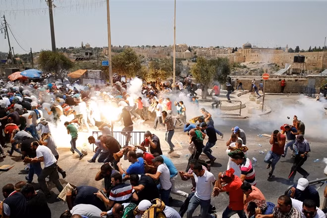 Lực lượng an ninh Israel bắn hơi cay về phía người dân Palestine. Ảnh: Reuters
