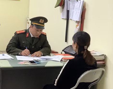 Điều tra viên Cơ quan ANĐT Công an tỉnh Lào Cai hỏi cung đối tượng Phạm Thị Khuyên.