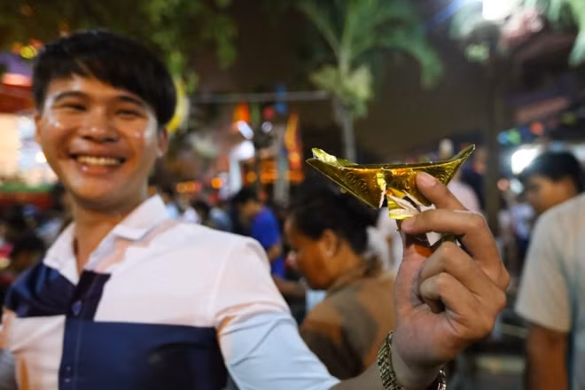 Nam thanh niên 20 tuổi nhặt được thỏi vàng giấy đã bị rách. "Vàng bị hư hỏng nhưng em vẫn thích vì lộc này ý nghĩa lắm. Có mấy người hỏi xin nhưng em không cho được", chàng trai cho biết.