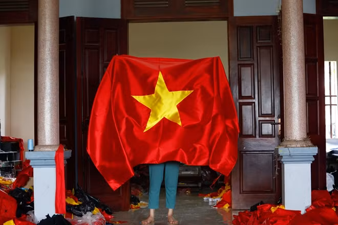 Nhìn từng lá cờ Tổ Quốc tự tay làm ra, vợ chồng anh Phục luôn tự hào về nghề truyền thống của gia đình.