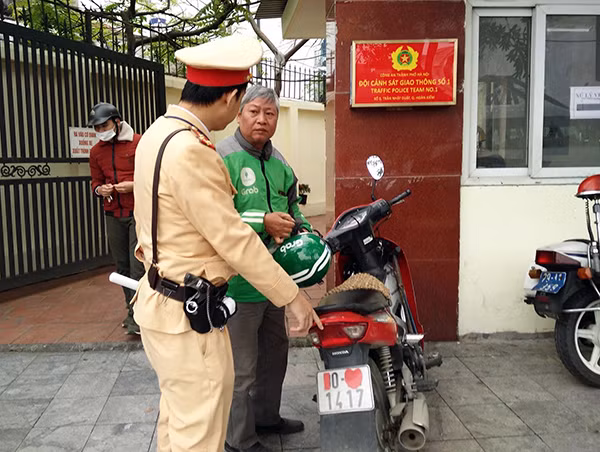 Tài xế xe ôm che biển số xe.