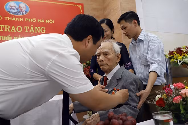 Đồng chí Nguyễn Minh Tâm gắn huy hiệu 75 tuổi Đảng cho Thiếu tướng Nguyễn Duy Phê.