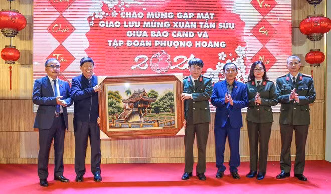 Đại tá Phạm Khải trao tranh lưu niệm tặng ông Nguyễn Văn Hùng và ban lãnh đạo Tập đoàn Quốc tế Phượng Hoàng.