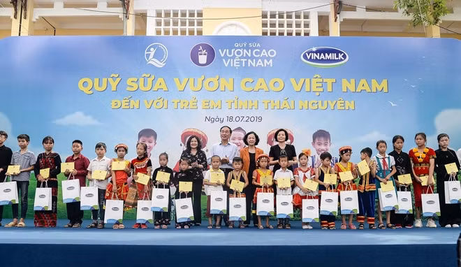 Bà Trương Thị Mai, Ủy viên Bộ Chính trị, Trưởng Ban dân vận Trung ương và đại diện Công ty Vinamilk trao tặng học bổng và quà cho các em học sinh.